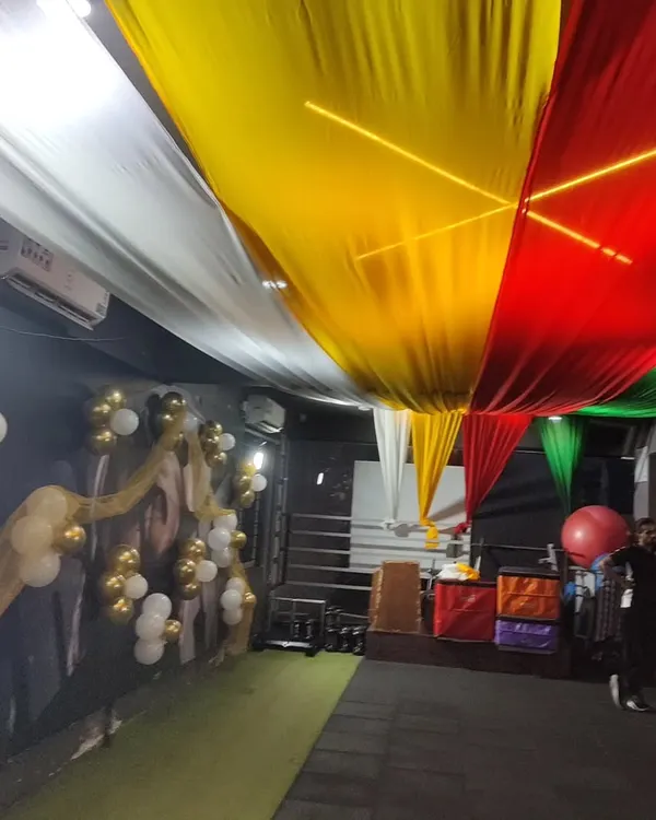 I can decorate any type of venue, including commercial spaces like this gym. For their Dandiya event, I used long drapes of colorful fabric across the ceiling and added balloon clusters to bring a festive feel to the workout area.