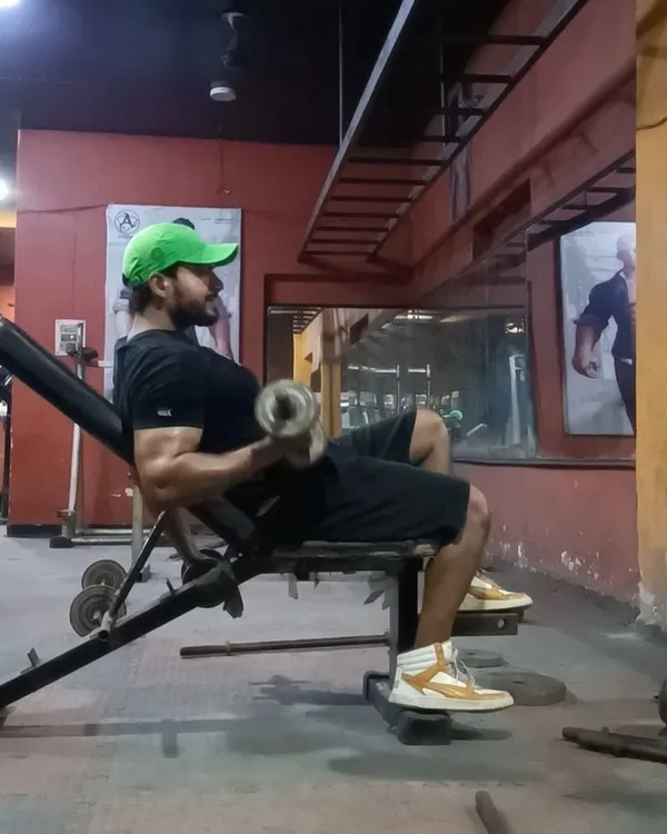 Perfecting the form on a seated dumbbell curl. This exercise is excellent for building bicep strength and size.