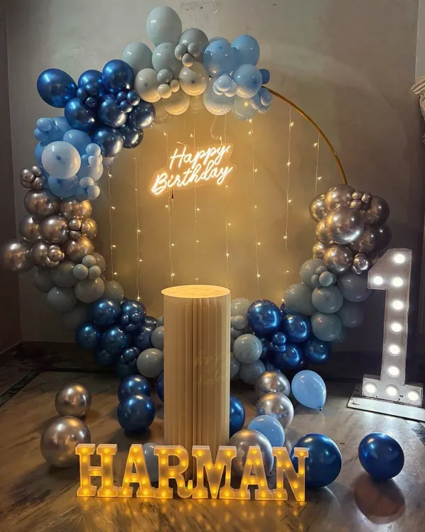 A baby's first birthday is always a precious milestone. For Harman's big day, we designed this beautiful blue and silver setup with a full balloon ring, a light-up number '1', and his name in glowing marquee letters.