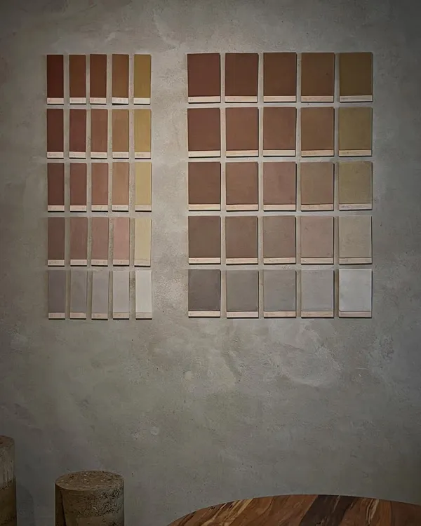 We are always learning and exploring new techniques in earth construction. These sample tiles showcase a range of earth plaster finishes, each with a unique color and texture derived from different soil compositions and pigments.