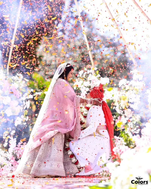 A magical moment from the Varmala ceremony, where the couple is showered in a rain of flower petals under a beautiful floral mandap. This is the kind of fairytale shot I love to create.