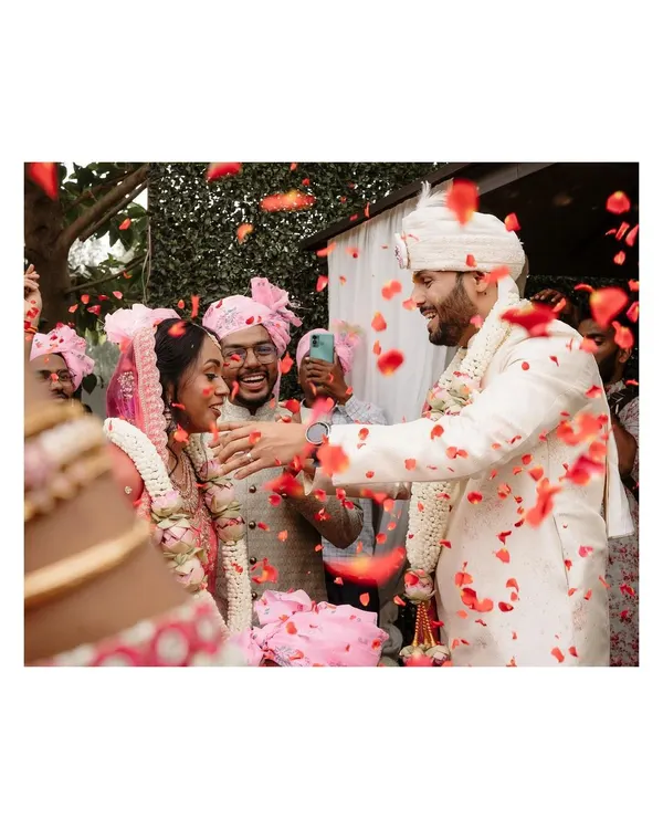 A candid moment of joy as the couple is showered with rose petals by their friends and family. This is the kind of spontaneous happiness we love to capture.