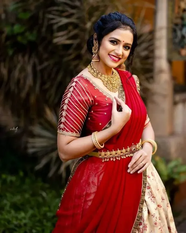 A beautiful half-saree look for the inspirational Rashmi Prabhakar. The makeup is bright and fresh, with a focus on radiant skin, a defined red lip, and eyes that sparkle, creating a perfect festive look.