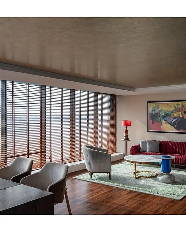 The MD's suite in 'The Office with A View' combines a meeting area and a private cabin. We repurposed much of the existing furniture while adding new elements like champagne leafing on the ceiling to create a refreshed, sophisticated look.