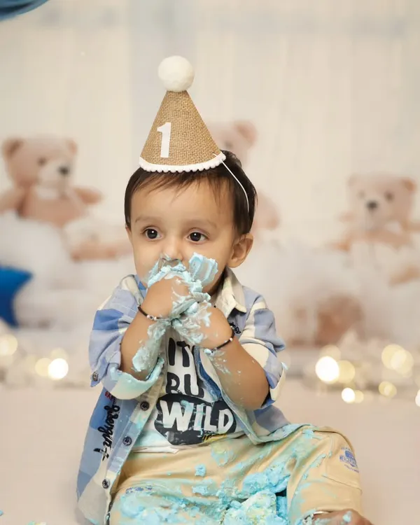 Look at those little hands covered in blue cake! This is the best part of a cake smash session, the pure, messy joy. This little boy is having the time of his life during his pre-birthday shoot in our Jaipur studio.