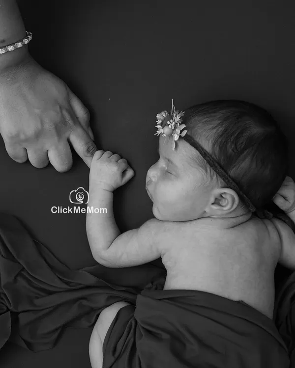The moment your baby's tiny hand wraps around your finger is pure magic. In black and white, this simple gesture becomes a powerful symbol of your new bond.