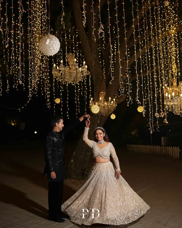 Dancing under a sky of your own. For this 'Starry Night' Sangeet, we hung thousands of fairy lights and crystal chandeliers from the trees to create a truly magical, open-air dance floor.
