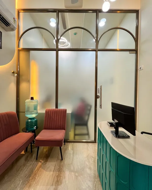 The entrance to the doctor's cabin at the Powai dental clinic, featuring frosted glass with arched details. This design choice provides privacy while allowing light to filter through, maintaining a bright and open feel in the commercial space.