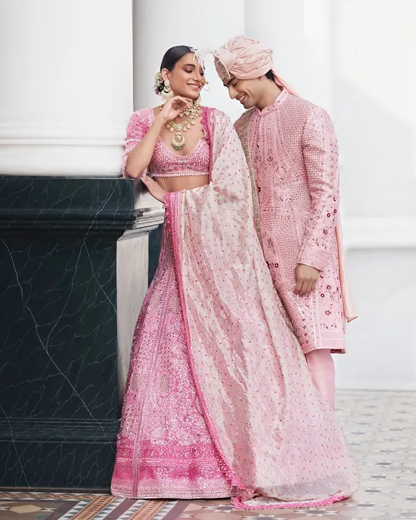 This is what dream wedding outfits are made of. I designed this stunning pink lehenga with intricate, all-over embroidery for her and a perfectly coordinated blush pink sherwani for him. Every detail, from the groom's subtle floral patterns to the bride's flowing dupatta, was crafted to create a truly unforgettable look.