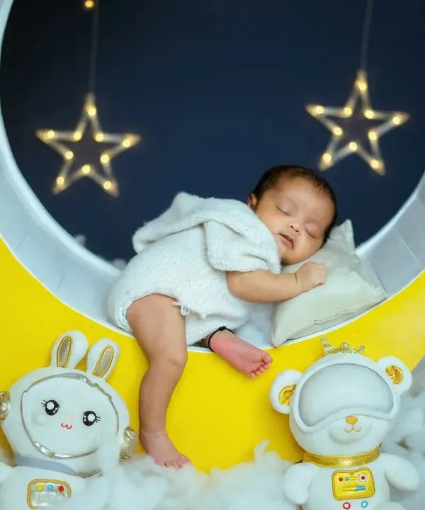 This is one of my absolute favorite newborn themes, the 'Blue Moon' setup. I create this dreamy scene right in my studio with soft clouds and twinkling stars, making sure your little one is safe and comfortable while we capture these precious sleeping moments.
