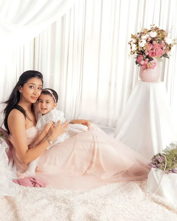 A dreamy mother-daughter portrait in our light and airy studio setup. The soft fabrics and floral arrangements create a beautiful, ethereal feel.