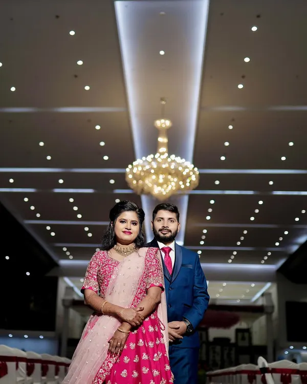 A classic wedding reception look. The couple stands against a beautiful floral wall, ready to greet their guests in a hall that I've decorated to feel grand and welcoming.