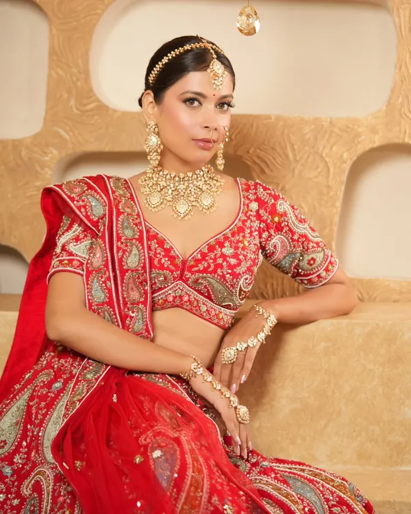 A classic bridal portrait featuring a stunning gold-look polki set. The ensemble includes a detailed choker, matching earrings, and a maang tikka, creating a complete and regal look for your wedding day.
