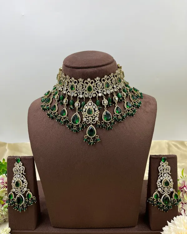 A heavy bridal choker set in a stunning emerald green. This design features multiple layers of stones and bead droppings, complete with matching oversized earrings, making it a comprehensive offering for your bridal customers.