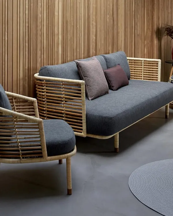 This is a complete handcrafted cane living room set, featuring a three-seater sofa and a matching armchair. The modern design combines a natural cane frame with dark grey cushions, showing how my furniture can fit into contemporary home interiors.
