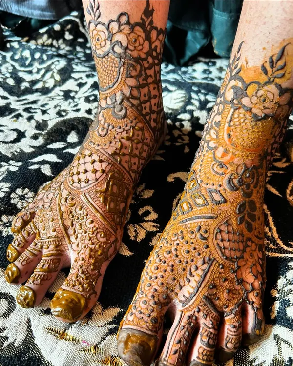 A beautiful and intricate bridal foot mehendi design. The pattern covers the entire top of the foot and extends to the ankle, creating a look as detailed as the hands.