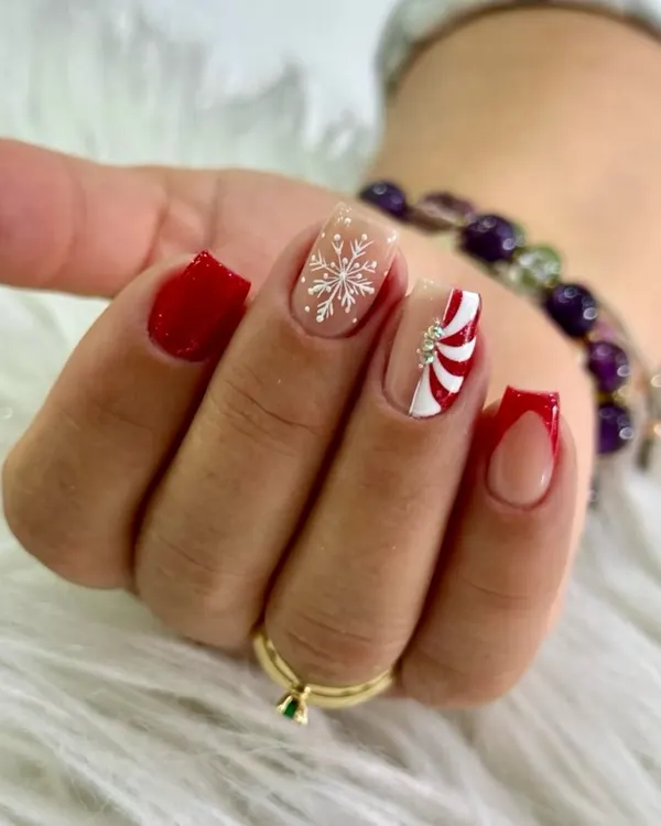 Christmas nails with main-character energy. This set is a statement, featuring classic crimson, a crisp snowflake detail, a candy-cane twist, and a bold red French tip.