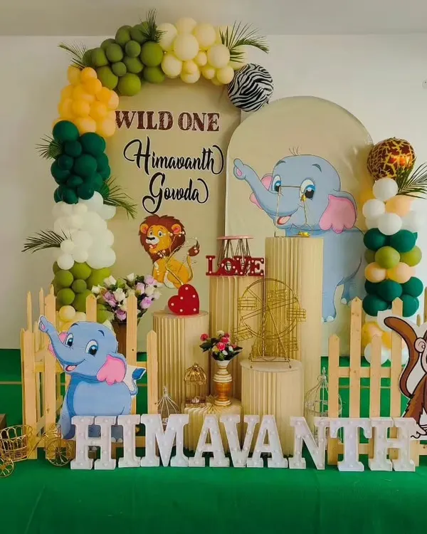 A "Wild One" jungle theme is one of our specialties. This setup for Himavanth's first birthday features cute animal cutouts, a lush green color palette, and a custom backdrop for a fun-filled celebration.