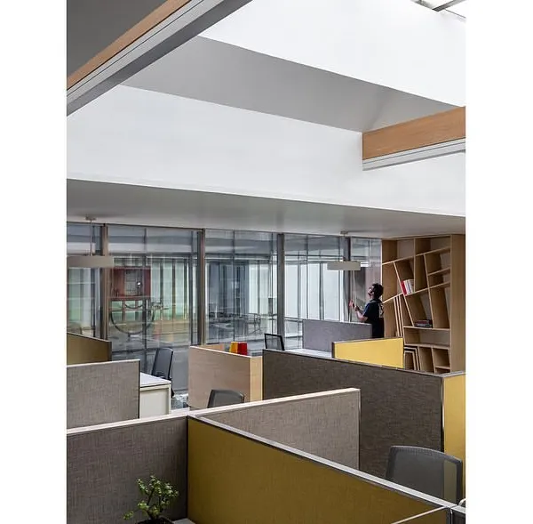 A skylight brings natural light into the central workstation area on the director's floor of the Stainless Steel Office. The design incorporates display shelving for Arttdi’nox products, blending a functional design studio with a product showcase.