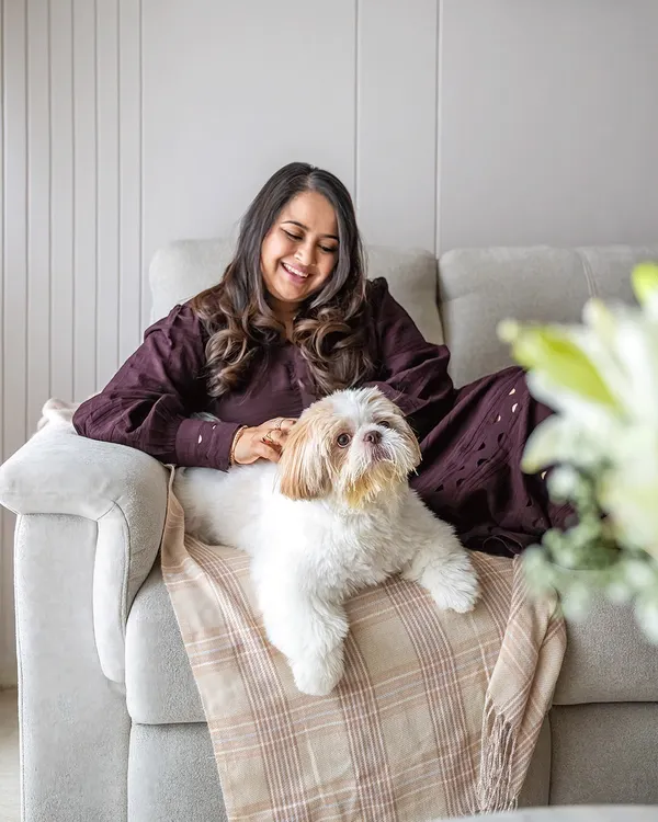A beautiful, relaxed portrait of Shruti and her Shih Tzu, Kyro, cuddling on the couch. At-home sessions allow for this kind of natural comfort and genuine connection.