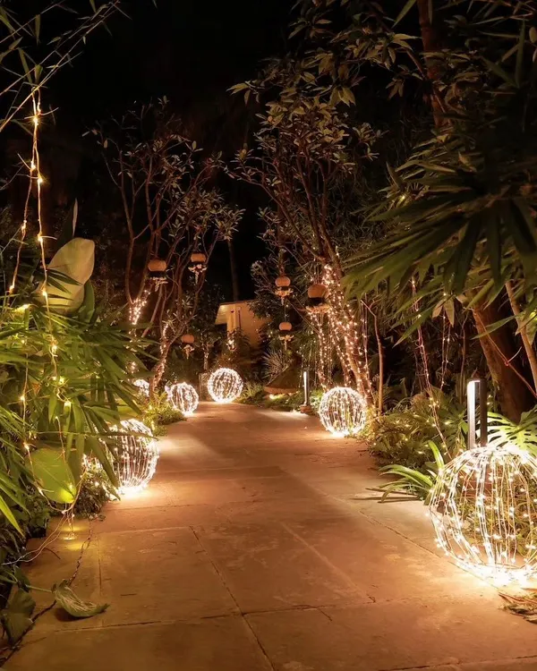 A magical walkway I created for a night event, lined with glowing orbs and hanging fairy lights. The path, surrounded by bamboo, guides guests through a forest of light, setting a dreamy tone for the evening.