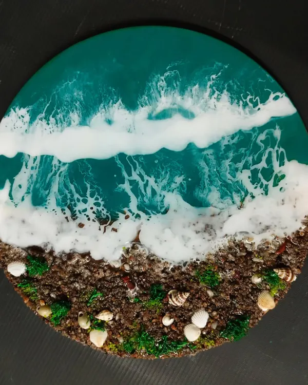 A stunningly realistic beach scene created with resin art. In our workshops, you will learn how to mix pigments, create wave effects, and use real sand and shells to craft your own beautiful piece of coastal decor.