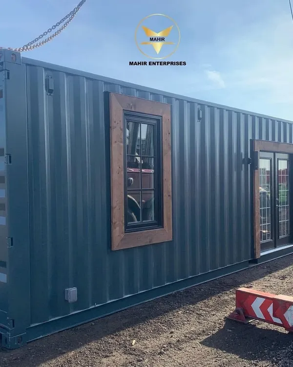 A custom container home, successfully delivered and placed on-site. The combination of industrial steel with warm wood accents and French doors creates a modern and inviting living space.