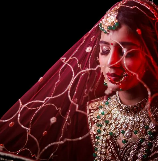 This is the kind of shot I love to create. Using a vibrant red veil and focused lighting, I aimed to capture a moment of quiet anticipation for the bride, highlighting the rich color of her attire and the emotion of the day.