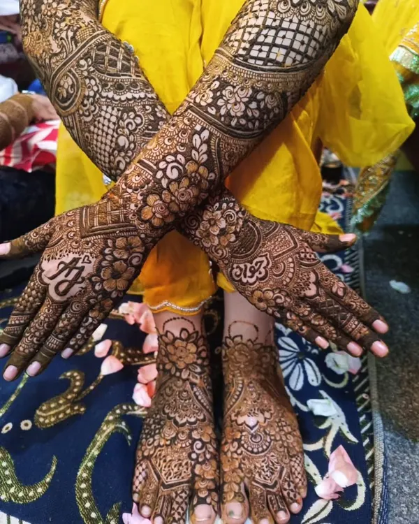 This is the complete bridal mehendi experience. I created a detailed, matching design for this bride's hands and feet, including her and her partner's initials for a personal touch.