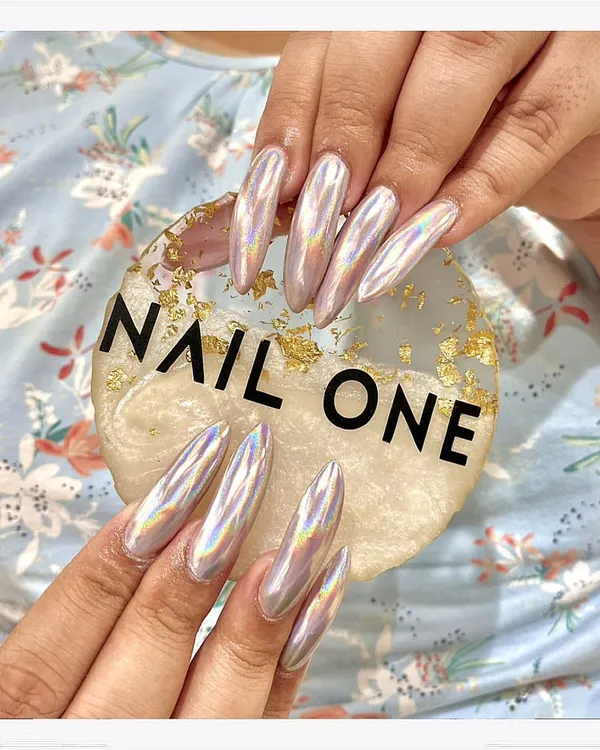 This is where nail art becomes a statement. We sculpted these long, almond-shaped acrylic extensions and finished them with a mesmerizing holographic chrome powder that catches the light from every angle. This look is for those who want their nails to be the center of attention.