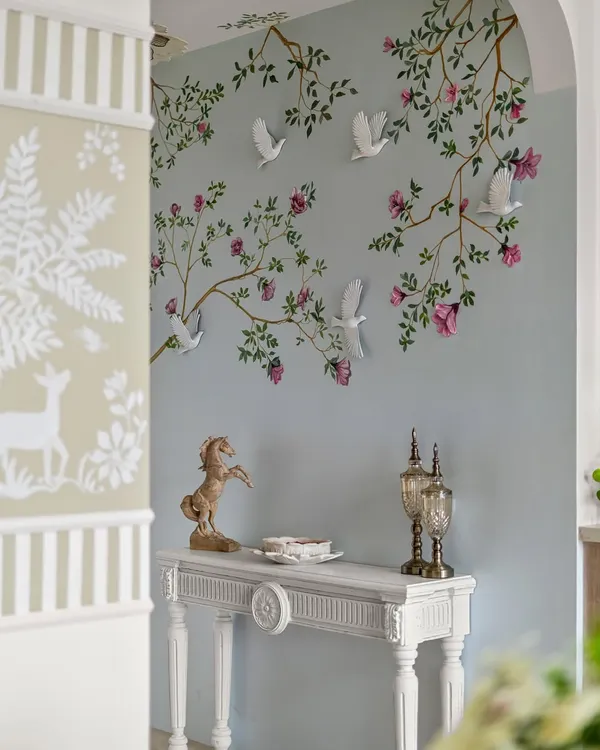 It’s corners like these that create a true sense of calm and belonging. This foyer isn’t just an entryway; it’s a warm embrace, with its hand-painted mural and elegant console table.