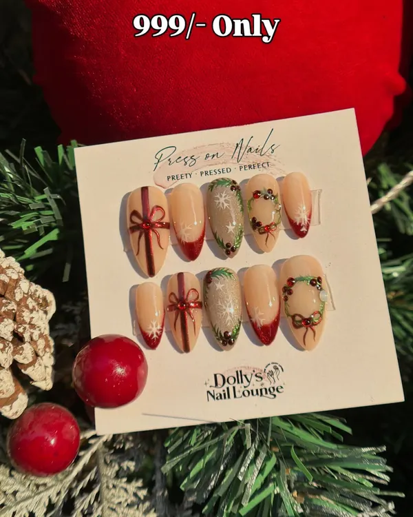 Get into the holiday spirit with these festive press-on nails. This set features hand-painted wreaths, bows, and a touch of red French tip.