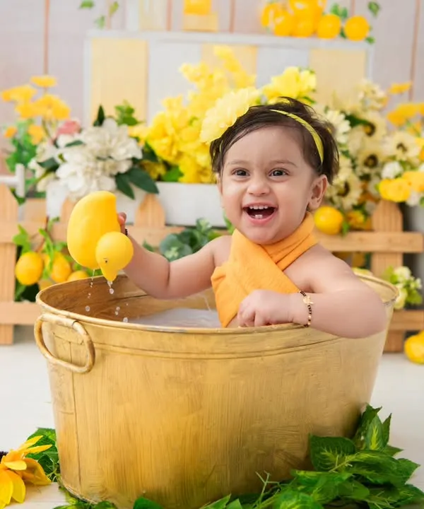 A lemon and sunflower themed milk bath. The bright yellow colors and the baby's happy expression make this a wonderfully cheerful and vibrant portrait.