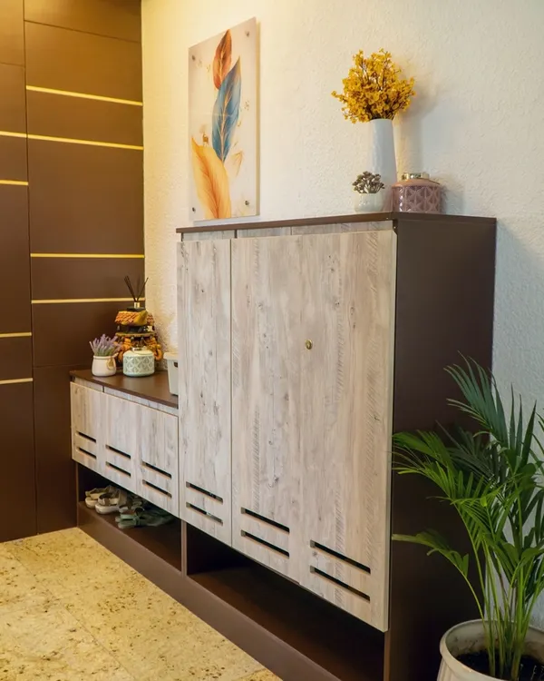A welcoming and organized entryway is essential. I designed this custom foyer unit with a ventilated shoe rack in a light wood finish and a taller dark wood cabinet to conceal utility panels, creating a clean and stylish first impression.