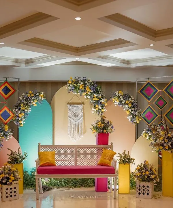 A truly Insta-worthy Mehendi backdrop. I used a mix of geometric patterns, pastel-colored arches, and a central macrame piece to create a modern, bohemian vibe for the bride's seating.