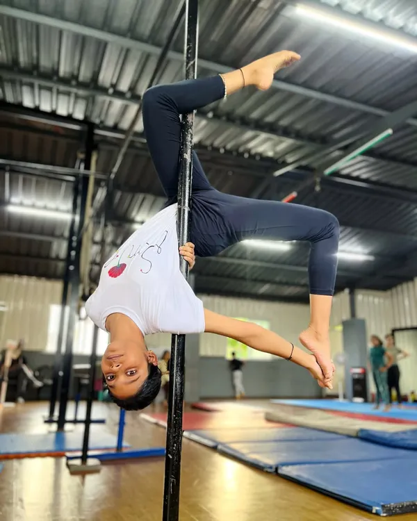Persistence meets elegance. This is a celebration of strength and grace, as this young student holds a perfect inverted stag pose on the pole.
