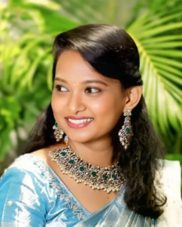 This is a perfect look for a wedding guest or a bridesmaid. My client is wearing a stunning statement choker with green stones that beautifully complements her light blue saree. It's elegant without being overpowering.