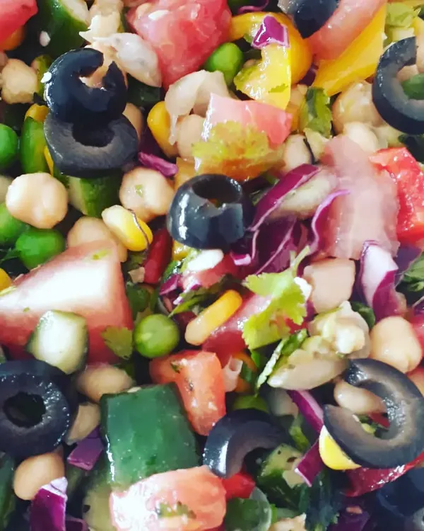 A colourful and high-protein Mediterranean salad. It's packed with chickpeas, fresh vegetables like cucumber and tomatoes, and black olives, all tossed in a light, zesty dressing.