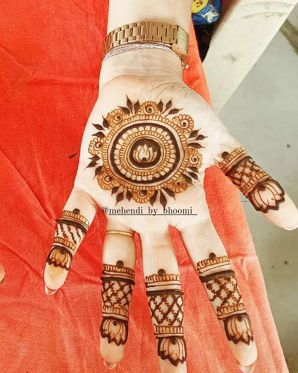 The mandala is a beautiful and popular choice for a minimal design. Here, a lotus is at the center, and the fingers have simple, matching bands to complete the look without covering the whole hand.