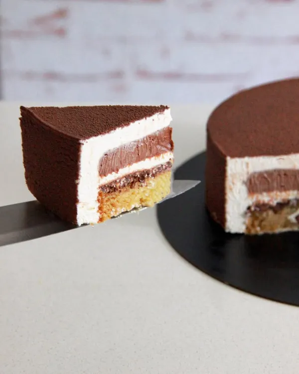 For the true coffee and hazelnut lover, an entremet is the ultimate indulgence. This cake features layers of mousse and cremeux, and this cross-section shows the beautiful textures inside.