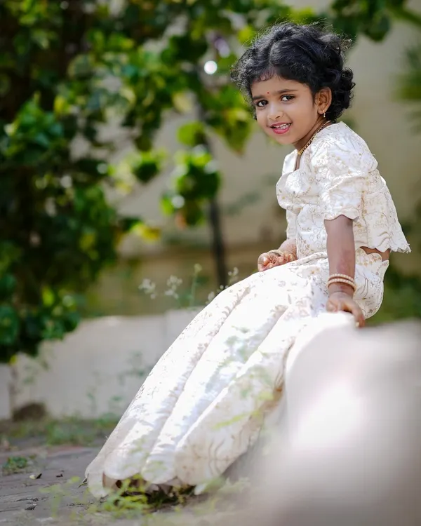 A custom-stitched off-white lehenga set for a little girl. The fabric has a beautiful self-design, and the outfit is designed for comfort, making it perfect for long hours at a family function.