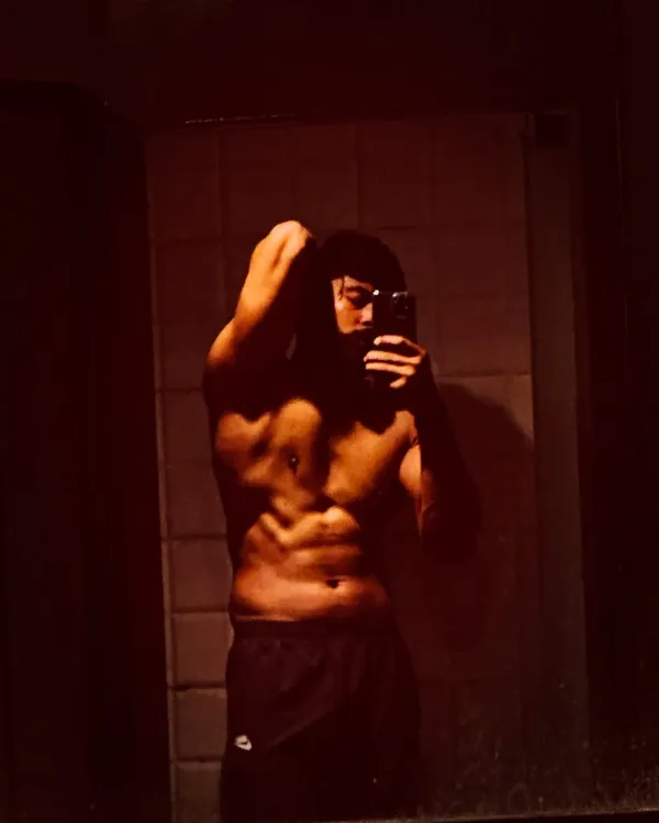 A shirtless mirror selfie showing a defined six-pack and upper body. The result of clean eating and hard training.