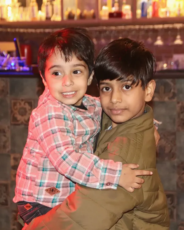 A sweet, candid moment of two brothers hugging during a family get-together.