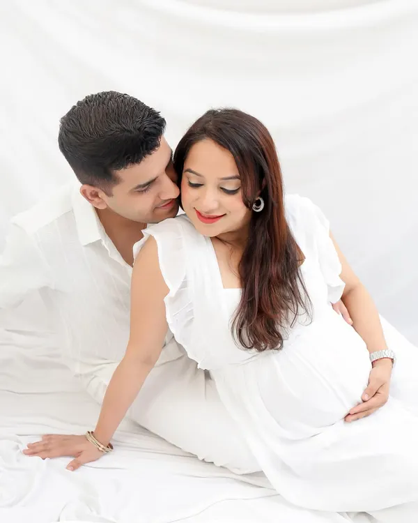A pure and gentle moment between parents-to-be, captured in my studio with soft, natural light. This high-key photography style creates a timeless and angelic feel, focusing on the quiet connection and love.