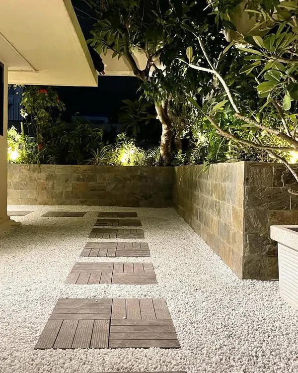 A corporate terrace in Mumbai transformed into a serene evening retreat. We believe a garden's magic shouldn't fade after sunset. The warm uplighting on the foliage and the clean lines of the white gravel path create a modern, tranquil atmosphere perfect for unwinding.