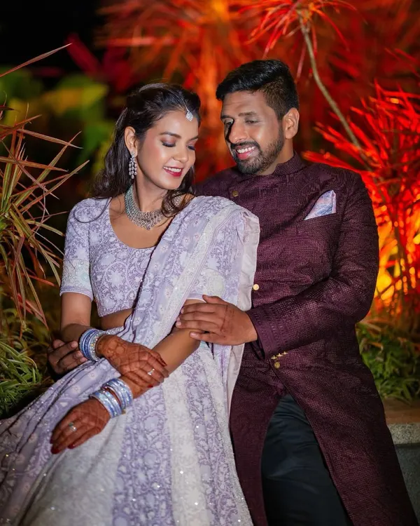 A lovely portrait of a couple during their Sangeet. The bride's lavender lehenga and the groom's deep wine sherwani complement each other perfectly, capturing their elegant style.