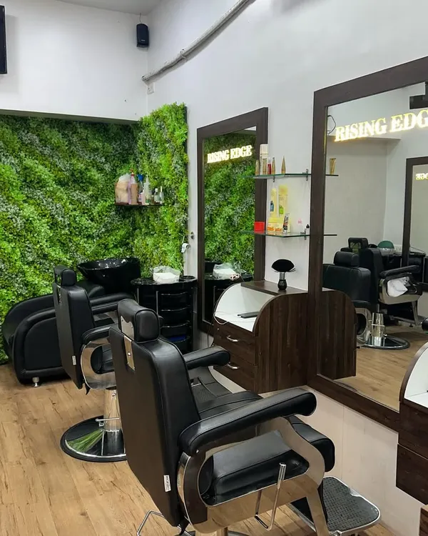 A look inside my salon. I prioritize a clean and professional environment, with comfortable barber chairs and a modern aesthetic featuring a green accent wall.