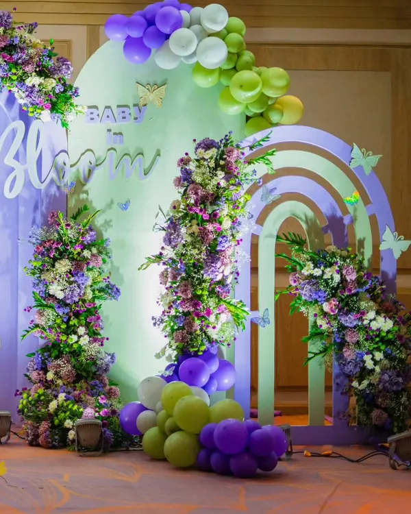 A gorgeous "Baby in Bloom" backdrop for a memorable baby shower. I used a palette of pastel purple, green, and white, with beautiful floral arrangements and balloon garlands to create this dreamy photo corner.