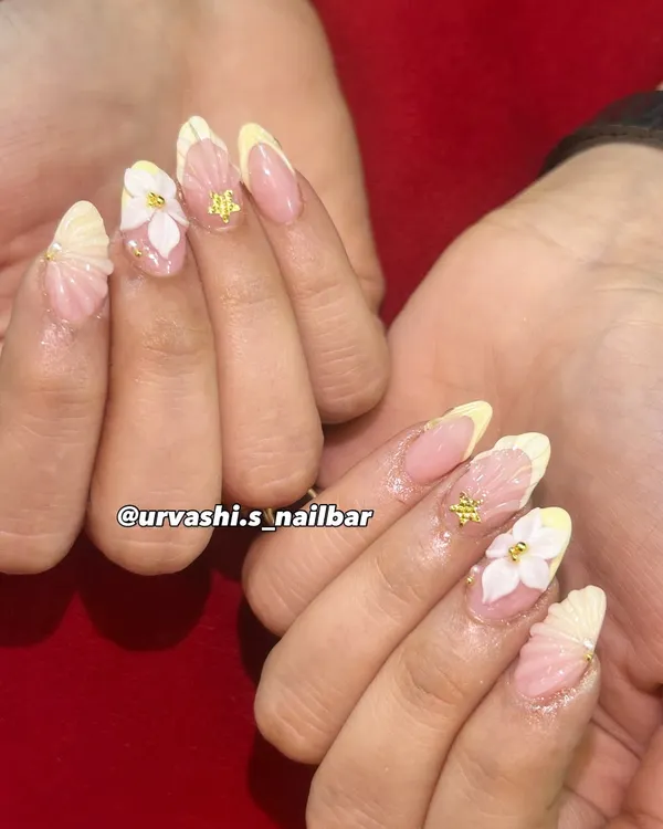 This elegant set features sculpted shell textures on the tips and hand-crafted 3D florals with tiny gold accents. The combination of textures on a soft blush base creates a truly sophisticated and artistic look.