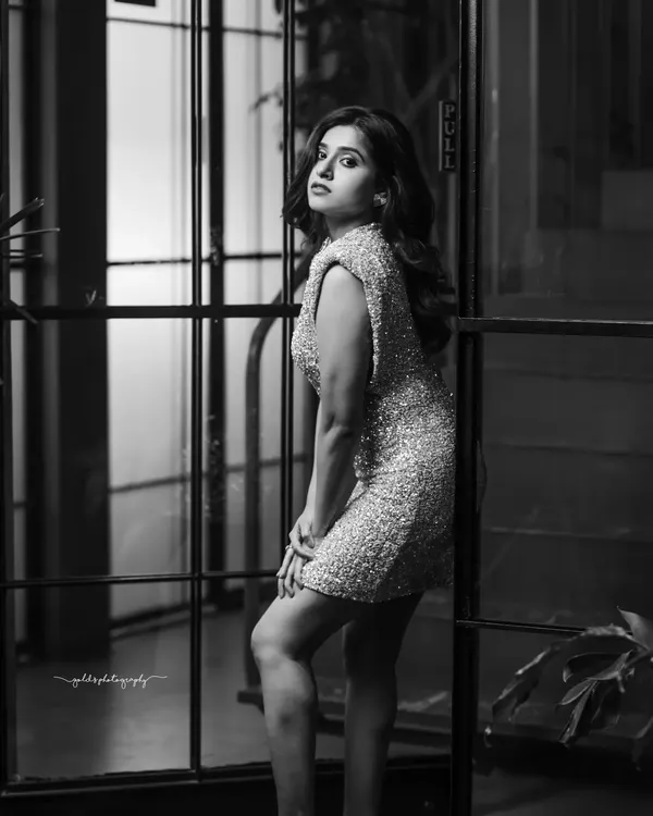 A striking black and white portrait of an actress in a glitter dress. The monochrome treatment emphasizes her pose and expression, creating a dramatic and high-fashion feel.